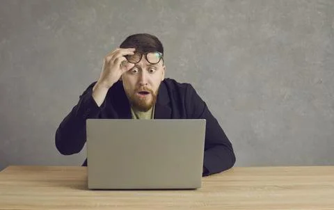 Scared man having problem with laptop and looking at screen with shocked face Stock Photos