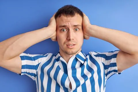 Scared man stressed by noise, closing ears with both hands, avoid people speech Stock Photos