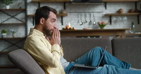 Scared man is unpleasantly surprised and shocked by the bad news seen on the Stock Footage 196940557