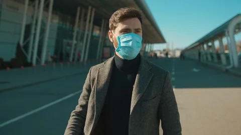 Scared man wearing Protective Face Mask near airport pandemic disease virus male Stock Footage 126578536