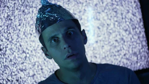 Scared man wearing tin foil hat in a front of TV Stock Footage 167541102