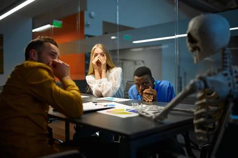 Scared managers and skeleton in IT office, joke Stock Photos