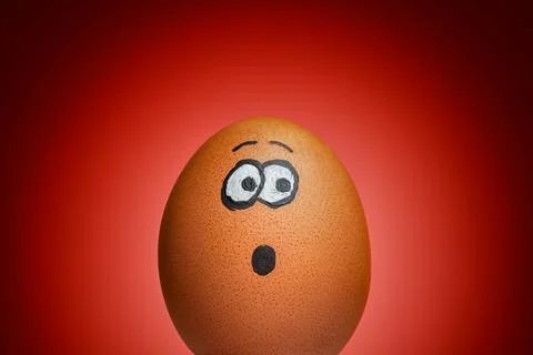 Scared or Surprised Egg on Dramatic Red Background 库存照片