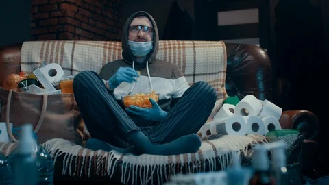Scared paranoiac man sitting in front of TV following pandemic covid-19 news Stock Footage 126654186