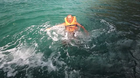 Scared sinking man in the sea with life jacket Stock Footage 51493607