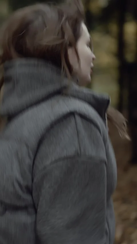 Scared woman looking back while running away through dark autumn forest Vídeos de archivo 320192154