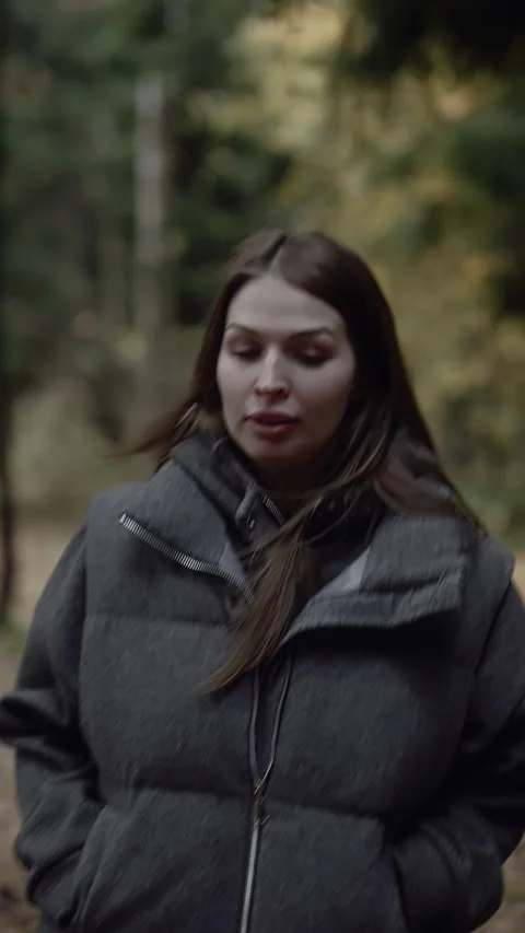 Scared woman looking back while running away through dark autumn forest Vídeos de archivo 320192194