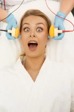 Scared woman screaming while getting facial treatment at the beauty clinic Stock-Fotos