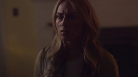 Scared woman working on computer and seeing lights in driveway Stock Footage 202903890