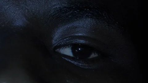 Scared young black man's eye in the dark.Fear, terror Stock Footage 119825377