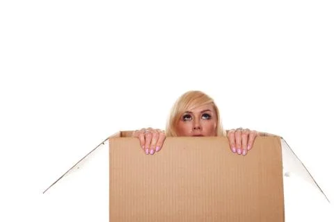 Scared young blonde emerging from a box Stock Photos