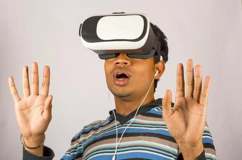 Scared young boy wearing virtual reality goggles and enjoying in scary 3D V.. Stock-Fotos