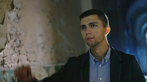 Scared young man in a dark hallway, holding an oil lamp in his hand. Dressed in Stock Footage 67346843