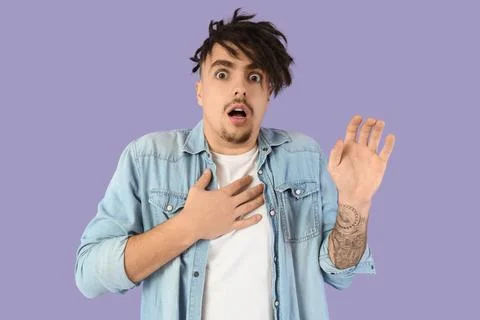 Scared young man having panic attack on lilac background Stock Photos