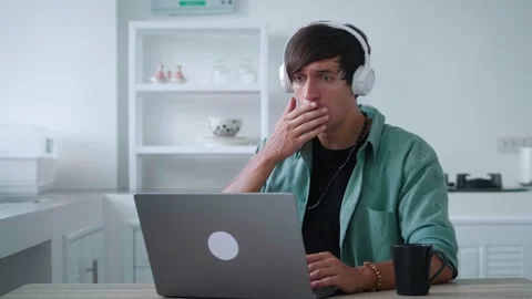 Scared young man in headphones getting bad results on computer at home office Stock Footage 188239653
