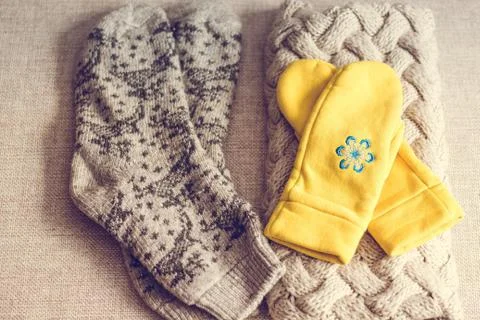 A scarf, warm socks with patterns and yellow stitches Stock Photos