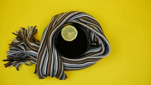 Scarf wraps mug of lemon tea. Place for text. Stop motion Video stock 118085733