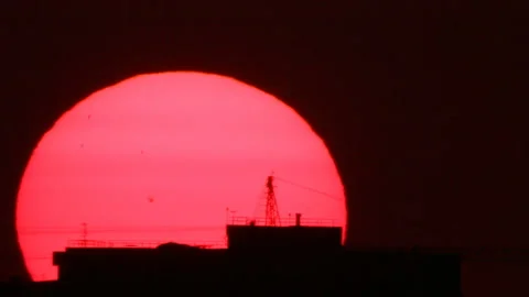 Scarlet sun behind building Stock Footage 113519284