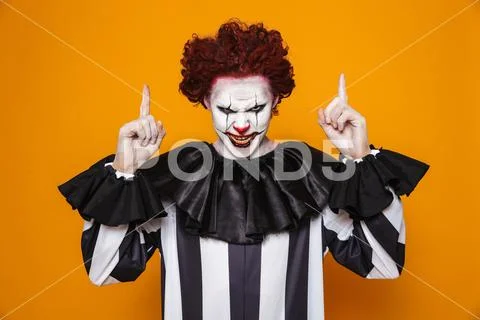 Scary angry clown pointing up at copy space Stock Photos