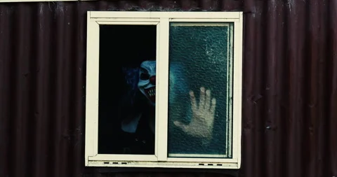 Scary clown appears in room window Stock Footage 273188342