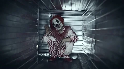 Scary clown attacks in a closed ventilation duct. Scary psychopath in a suit. Stock Footage 190593313