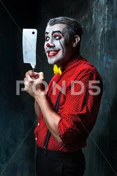 The scary clown holding a knife on dack. Halloween concept Stock Photos