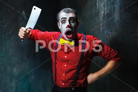 The scary clown holding a knife on dack. Halloween concept Stock Photos