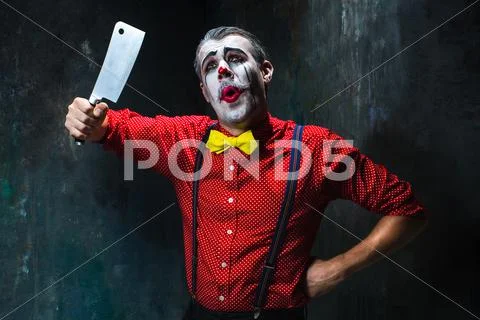 The scary clown holding a knife on dack. Halloween concept Stock Photos