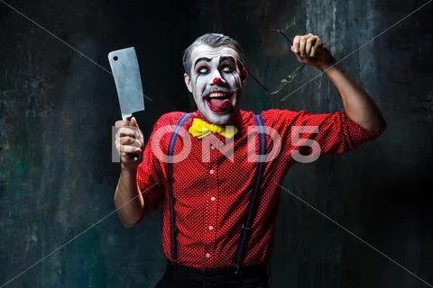The scary clown holding a knife on dack. Halloween concept Stock Photos