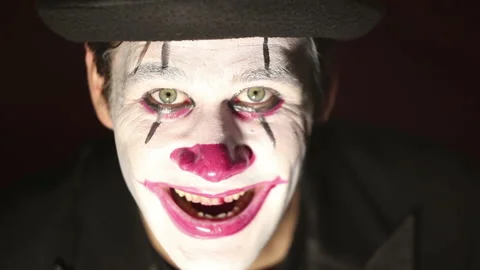 Scary clown looks at the camera and laughs terribly.  Halloween. Stock Footage 118672653