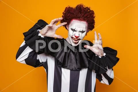 Scary clown with red hair scream to camera Stock Photos