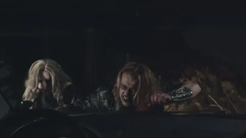 Scary couple of zombies looking through car window at night Stock Footage 141208348