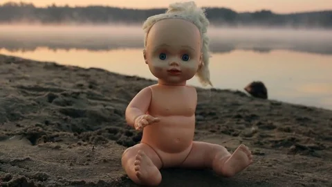 Scary doll lying on the beach Stock Footage 73191408