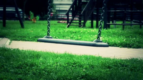 Scary empty swing with chains swaying at playground for child Video stock 56691943