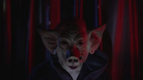 Scary Evil man with pig mask against red curtain with flashing lights Video stock 219854848