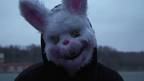 Scary evil maniac in a rabbit mask looks at the camera and prepares to kill 스톡 동영상 167738596