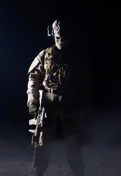 Scary fully equipped ghost warrior standing with rifle. Stock Photos