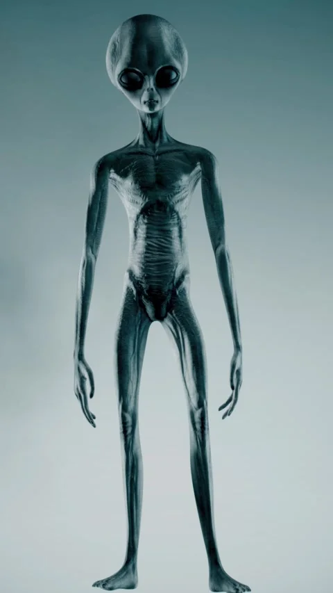 Scary gray alien stands and looks blinking on a dark smoky background. UFO 스톡 동영상 310963752