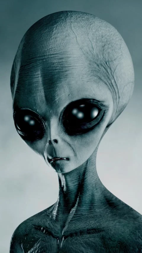 Scary gray alien stands and looks blinking on a dark smoky background. UFO 스톡 동영상 310963774