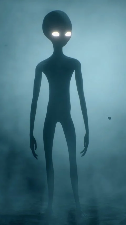 Scary gray alien stands and looks blinking on a dark smoky background. UFO 스톡 동영상 310963791