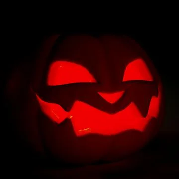 Scary Jack o lantern close up. Halloween pumpkin smiles and glowing at nigh.. Illustrazione stock