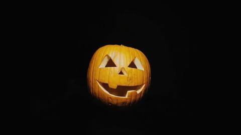 Scary Jack o'lantern appears out of the darkness. Stock Photos