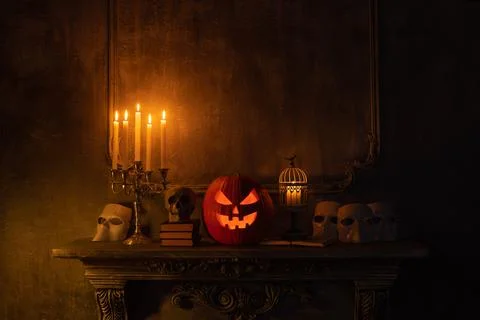 Scary laughing pumpkin and old skull on ancient gothic fireplace. Halloween Stock Photos