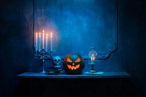 Scary laughing pumpkin and old skull on ancient gothic fireplace. Halloween Stock Photos
