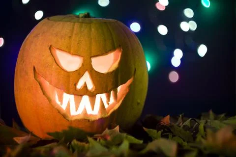 Scary lighted Jack O Lantern halloween pumpkin on bokeh dark background Foto stock