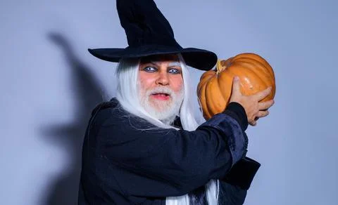Scary man in witch hat with pumpkin. Demon with Jack o lantern. Happy Hallowe Stock Photos