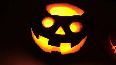 Scary pumpkin faces smiling in the darkness. hitting the camera scary pumpkin Stock Footage 102780188