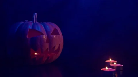 Scary Pumpkin Jack O Lantern with Flaring Candles. Halloween Background. Stock Footage 141045178