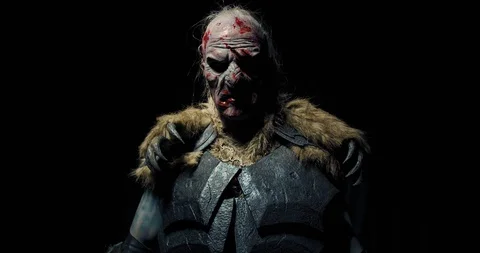 Scary realistic orc is putting the sword on his shoulder, 4k Video stock 130170909