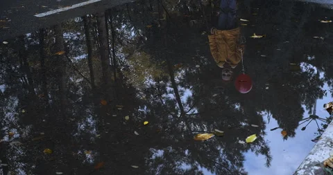 Scary reflection in the water of toddler kid boy in frightening clown make up Stock Footage 250028521